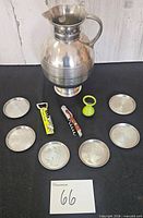 All items laid out: pewter pitcher, six coasters, three openers