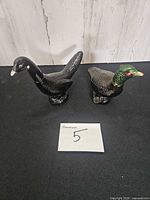 Two bird-shaped Avon cologne bottles on tabletop