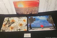 All three photographic placemats displayed on black cloth