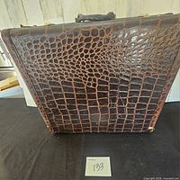Front view of dark brown alligator skin suitcase