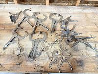 All fourteen locking pliers spread on workbench