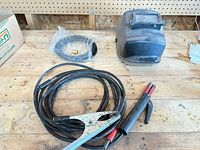 Overview of helmet, leads, clamp, hose on workbench