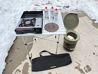 Overall lot with stove, table, toilet, fuel cans, bag and diffuser