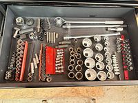 Drawer view showing assorted chrome sockets, ratchets, extensions, bit sockets on rails