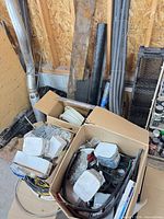 Overview of boxes with electrical boxes, cover plates, wiring and pipes