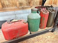 All four antique metal jerry cans on shelf