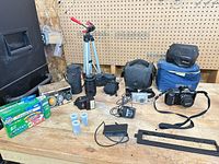 Overall lot layout showing cameras, lenses, tripod, film, accessories