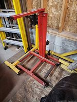 Overall view of red hydraulic door remover stand against wall
