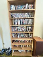 Tall wooden shelf filled with multiple rows of DVD and Blu-ray cases