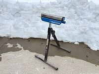 Full view of Mastercraft roller stand set up on pavement with snow background