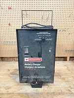 Front view showing MotoMaster branding, ammeter window, control switch, dust on surface