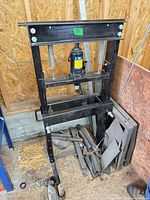 Full view of black steel frame shop press with bottle jack and springs