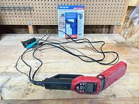 Timing light, leads, and packaged thermometer on workbench