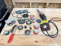All items laid out on bench: die grinder, rotary tool, wire brushes, discs, bits