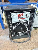 Front view of Sears 295-amp arc welder showing cabinet and cables