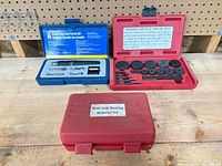 Three plastic tool cases on bench, two open showing contents