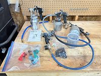 Overall lot view with spray guns, hoses, accessories on bench