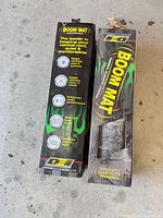 Front view of two unopened DEI Boom Mat boxes