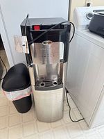 Front view of Whirlpool self-clean water cooler showing stainless body, drip tray, control panel