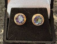 Earrings on velvet stand showing overall appearance and iridescent stones