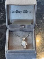Pendant necklace in open grey box marked Sterling Silver