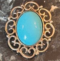 Front view showing turquoise cabochon and silver filigree frame