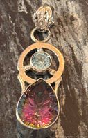 Front view showing mystic topaz drop, round light blue stone, sterling frame and bail