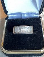 Front view of sterling silver ring showing channel-set clear baguette stones