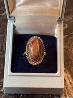 Ring in presentation box, front view showing opal and decorative border