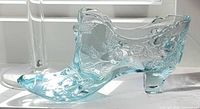 Left side view of aqua glass shoe showing floral relief