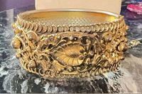 Front view of ornate gold-tone filigree bangle bracelet