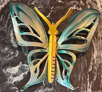 Front view of green-teal enamel butterfly brooch showing color gradient and openwork wings