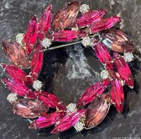 Front view of circular brooch showing marquise pink rhinestones and clear round accents