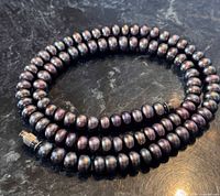 Coiled view of entire freshwater pearl necklace showing colour and clasp