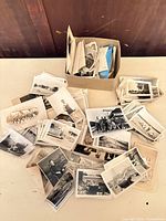 overview of box and spread out vintage photos on table