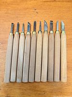 Full set of ten carving tools lined up showing handles and blades