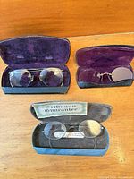 Group shot of three eyeglasses in open cases