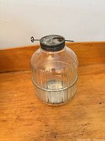 Full view of ribbed glass Hoosier jar with metal lid