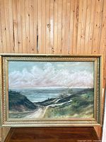 Full view of framed coastal landscape painting