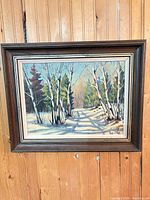 Framed winter landscape painting on wood wall