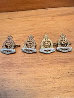 All four RCAMC cap badges front view