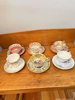 All six teacup and saucer sets displayed on tabletop