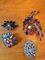 Front view of all four brooches showing stone colours and designs
