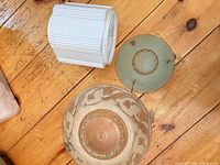 All three glass light shades laid out on wood floor