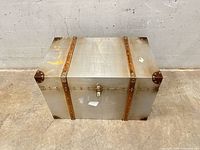 closed chest showing exterior panels, wood slats, brass hardware