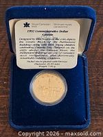 Coin in blue velvet clamshell presentation case with specification card