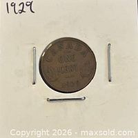 Coin in cardboard holder showing reverse inscription CANADA ONE CENT 1929