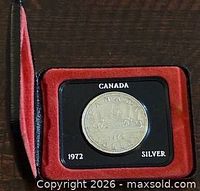 Closed black case showing coin in red-lined interior