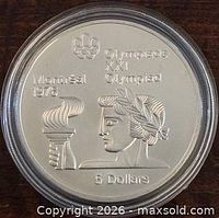 Obverse of coin with Athena holding torch, denomination, capsule visible