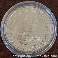Obverse of coin showing Prince Charles and Lady Diana Spencer with inscription and wedding date, coin inside capsule